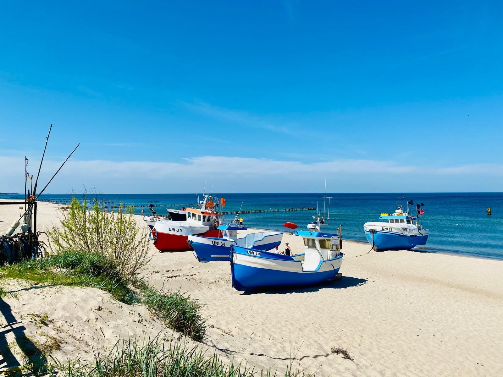 Kutry rybackie na plaży i drewniane falochrony